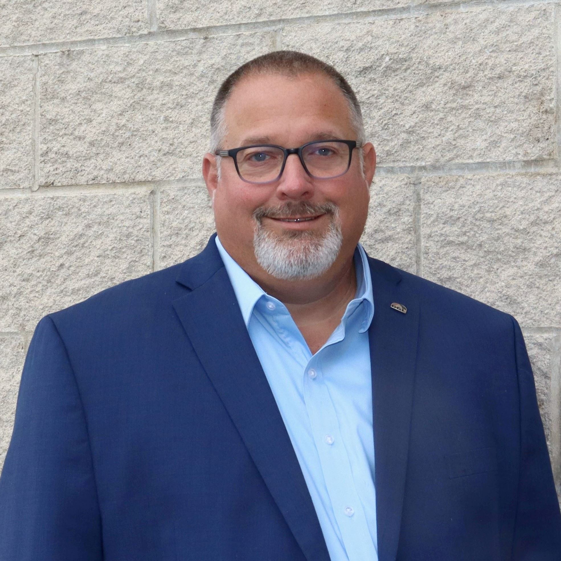 man with glasses and suit jacket and white button down shirt